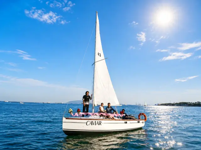 The sailboat Caviar under full sail with a family of guests aboard
